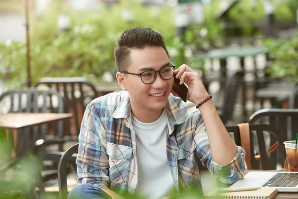 Happy Asijské Mladý Muž Sedí Venkovní Kavárně Mluví Telefonu — Stock fotografie