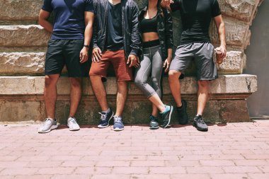 Sportif insanlar duvar, kısmi görünümü ayakta bacaklar