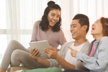 Dijital tablet bir şey izlerken gülmekten Asya gençler
