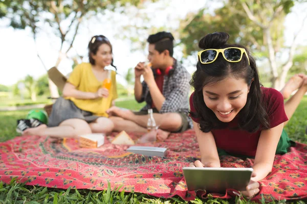 Leende Flicka Liggande Filt För Picknick Och Använda Digitala Surfplatta — Stockfoto