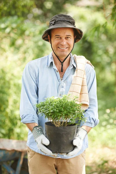 Portrait of happy man holding flower he is going to plant