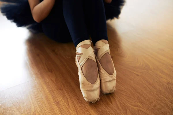 芭蕾舞演员穿着芭蕾舞鞋和坐在木地板上的部分看法 — 图库照片