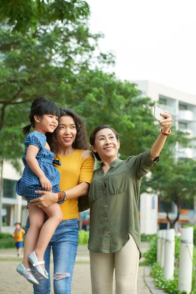 彼女の愛らしい小さな孫娘と Selfie を取ってうれしそうな高齢者の女性と公共の公園 家族の肖像画のショットでかなり娘 — ストック写真