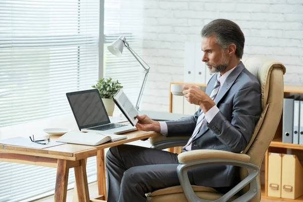 Uomo Affari Maturo Che Beve Caffè Legge Informazioni Sullo Schermo — Foto Stock