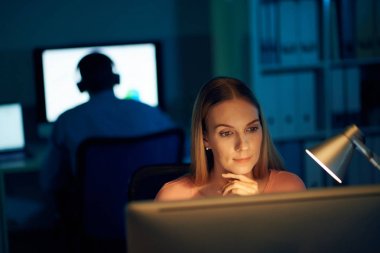 Karanlık ofisinde çalışan genç ve güzel iş kadını