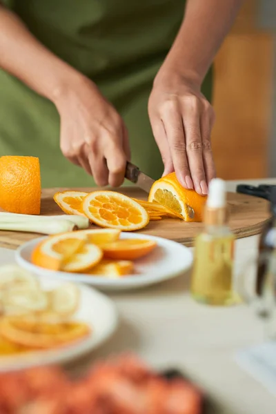 妇女的手切片成熟的橙色在切割板上 — 图库照片
