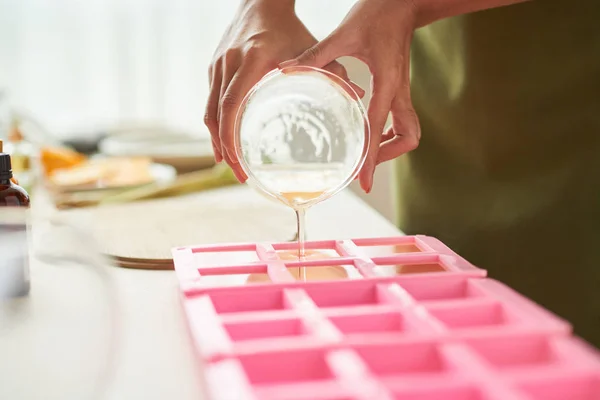 プラスチック フォームに石鹸の混合物を注ぐ女性のクローズ アップ画像 — ストック写真