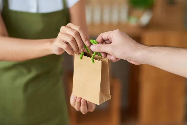 Sprzedawczyni Daje Worek Papierowy Ogranic Kosmetyki Klienta — Zdjęcie stockowe