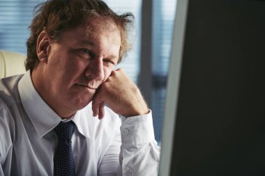 Sıkılmış işadamı bilgisayarda raporu okumak gerekiyor