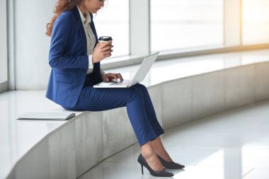 Kahve içme ve bilgisayarda çalışan kadın iş yürütme görüntü kırpılmış