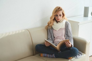 Onun odasına kanepede oturan ve bir kitap okuma güzel genç kadın