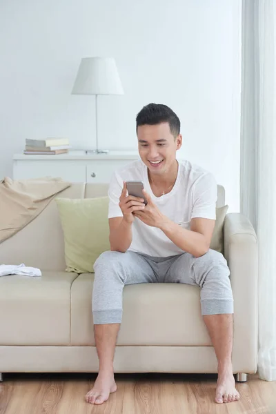 Cheerful Young Asian Man Reading Messages His Smartphone — Stock Photo, Image