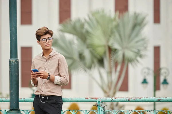 Jeune Homme Vietnamien Attrayant Avec Smartphone Debout Dans Rue Écoutant — Photo