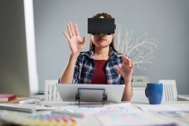 VR kulaklık geniş ofis masa başında otururken iş için kullanan kadın