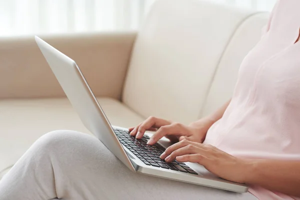 女性坐在沙发上的特写图像和笔记本电脑的工作 — 图库照片