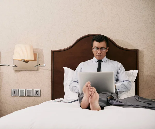 Босоногий Бізнесмен Лежить Ліжку Працює Ноутбуці Готельному Номері — стокове фото