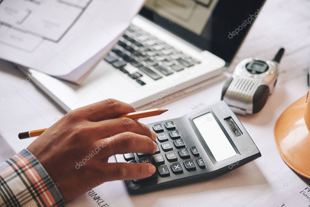 Hands of engineer calculating budget estimate for project