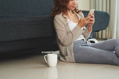 Bir fincan kahve ve manifatura ile katta oturan kız Resim kırpılmış