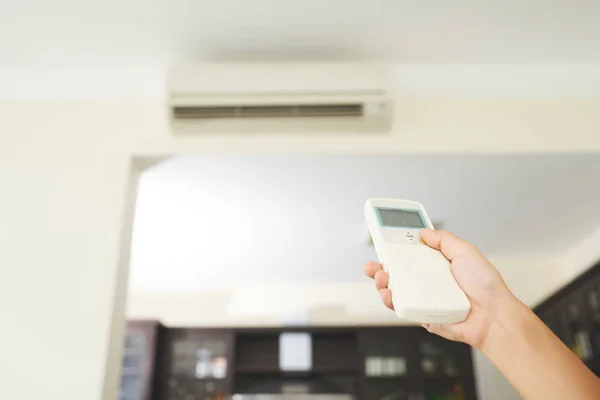 Hand Der Frau Mit Fernbedienung Zur Temperaturänderung Raum — Stockfoto