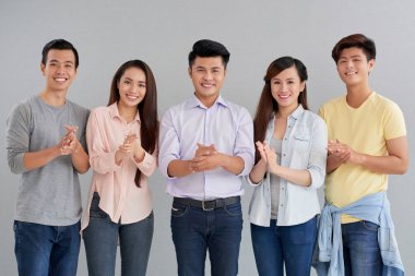 Alkışlar ve kameraya bakarak gülümseyen Vietnamca üniversite öğrencileri