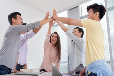 Birbirimizi beş yüksek vererek mutlu Asya gençler