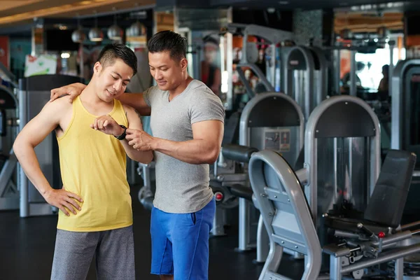 Sorrindo Desportista Vietnamita Mostrando Rastreador Fitness Para Seu Amigo — Fotografia de Stock