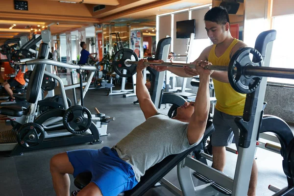 Treinador Fitness Controlando Jovem Que Está Fazendo Supino — Fotografia de Stock