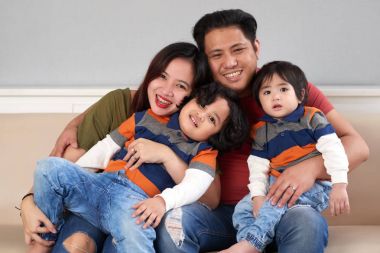 Eşi ve iki çocuğuyla sarılma mutlu Filipino adam