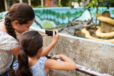 Kız ve küçük kız kardeşi çekim hayvanların hayvanat bahçesinde