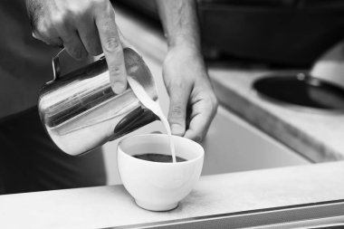 Barista kahve için süt ekleyerek ait siyah-beyaz fotoğraf