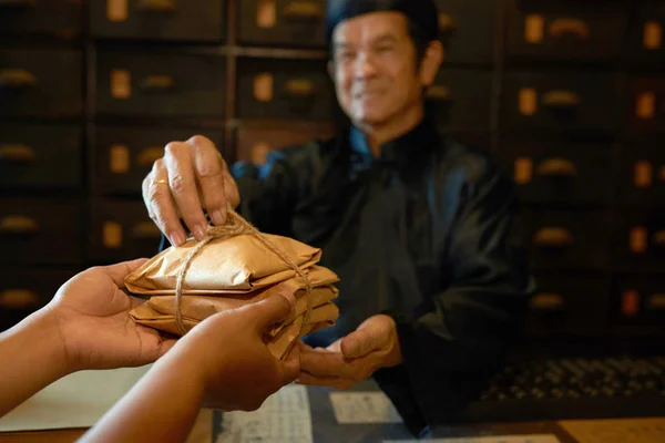 Традиционная Китайская Медицина Практикующий Дает Упаковки Травами Клиента — стоковое фото