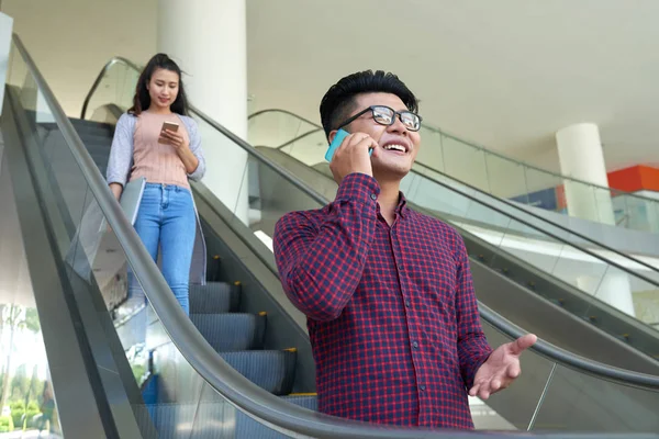 Cheeful Asiatique Jeune Femme Parler Téléphone Lorsque Debout Sur Escalator — Photo