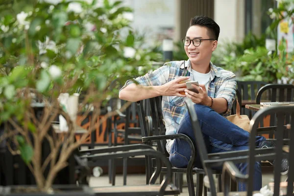 Hombre Asiático Alegre Sentado Aire Libre Con Taza Helado Teléfono —  Fotos de Stock