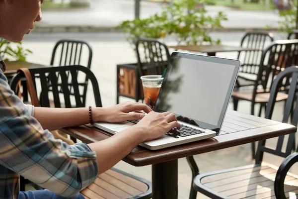 Copywriter working on laptop in outdoor cafe