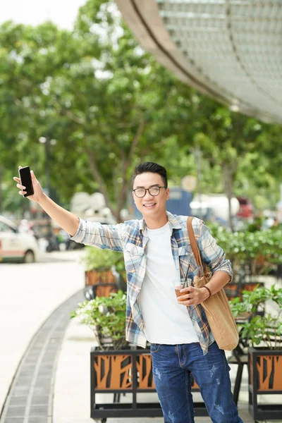 Neşeli Asya Genç Adam Elinde Taksi Yakalamak Smartphone Ile — Stok fotoğraf