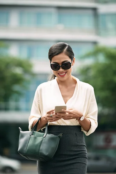 Joven Mujer Negocios Gafas Sol Sonriendo Leer Mensaje Teléfono Inteligente —  Fotos de Stock