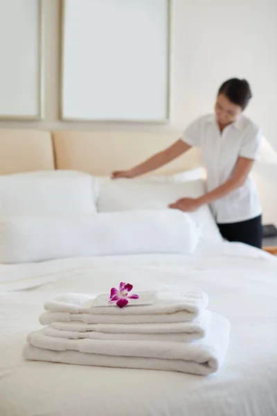 女佣为客人铺床 重点放在一堆毛巾上 — 图库照片