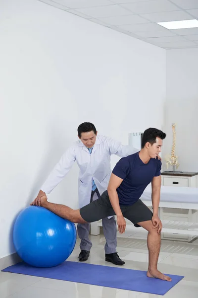 Physiotherapeutin Hilft Patientin Beim Turnen Auf Fitnessball — Stockfoto