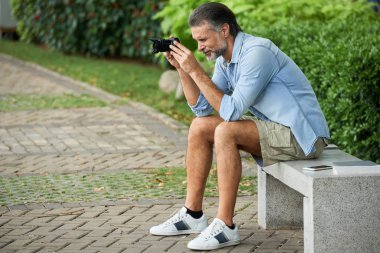 Rahat kıyafetler park ve çekici fotoğraf oturan orta yaşlı adam