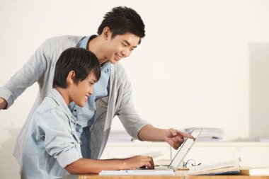 Genç Vietnamlı bir şey onun kız arkadaşı için dizüstü bilgisayarda gösterilen