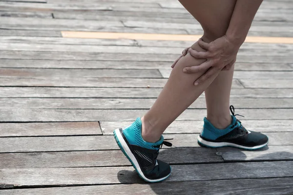 Female jogger having pain in calf muscle