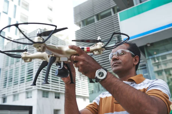Indian man in protective glasses launching his drone