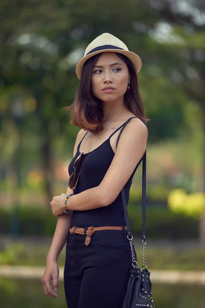年轻的越南妇女在草帽望去若有所思 而摆在可爱的绿色公园拍摄摄影 背景模糊 — 图库照片