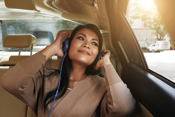 美丽的越南妇女坐在汽车和听她最喜欢的音乐 — 图库照片
