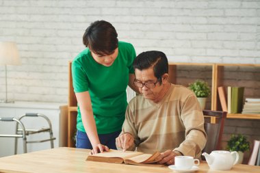 Asyalı kadın evde kitap okuma komuta sizde yardım