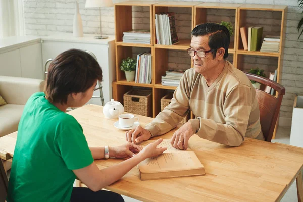 Aziatische Vrouw Met Senior Man Lezen Boek Thuis — Stockfoto