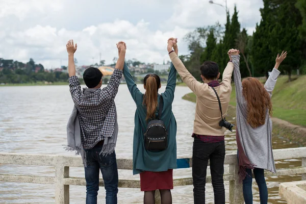 Вид Сзади Молодых Людей Держащихся Поднятые Руки Взгляде Реку — стоковое фото