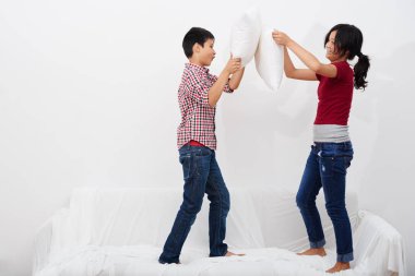 Kanepeye atlama ve yastık ile mücadele çocuklar