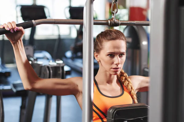 在健身房锻炼手臂和背部的漂亮女人 — 图库照片