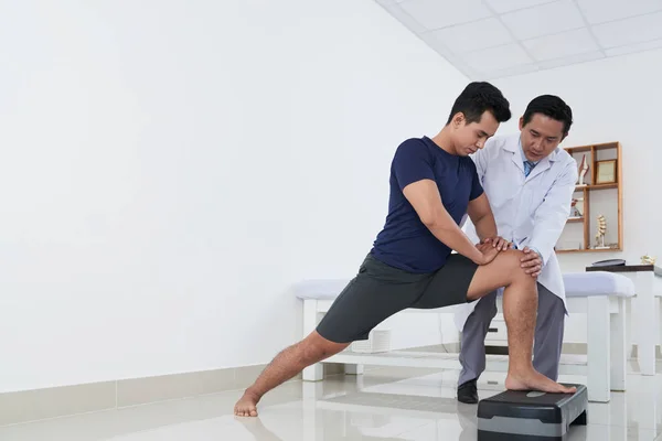 Junger Asiatischer Sportler Macht Sport Unter Der Kontrolle Eines Physiotherapeuten — Stockfoto